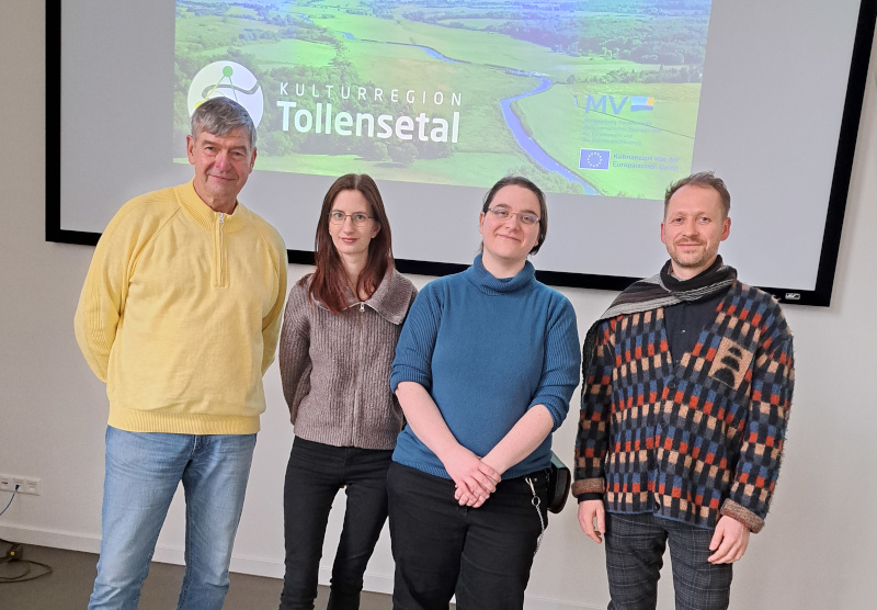 Gruppenfoto vor der Leinwand mit KwiT-Logo. V.l.n.r. Günter Kotterba, Pia Schulze, Anne Zandt, Thomas Radke